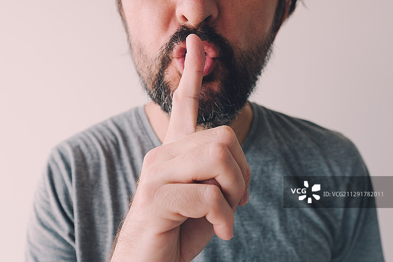 手指放在嘴唇上的男人的正面特写，塞尔维亚诺维萨德图片素材
