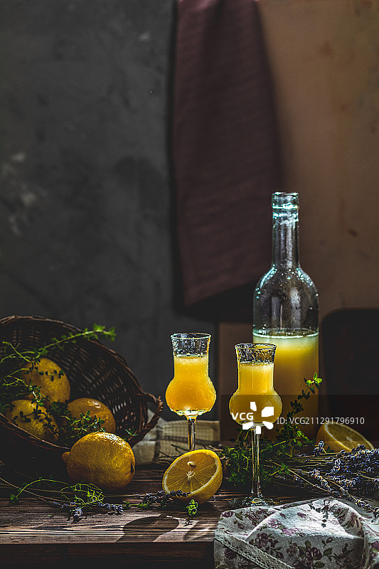 柠檬酒瓶和两杯柠檬酒特写，以及柠檬和薰衣草花静物图片素材