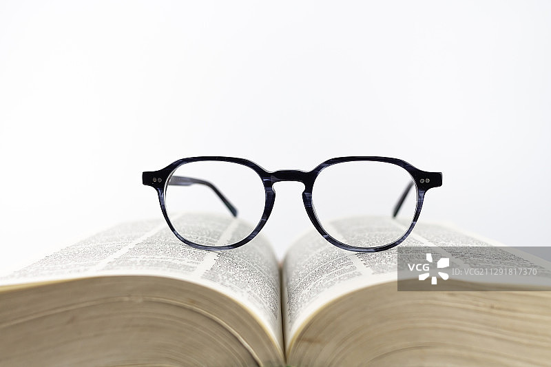 打开的书本上的老花镜图片素材