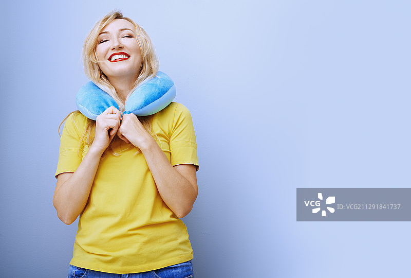 快乐的女人戴着颈枕图片素材