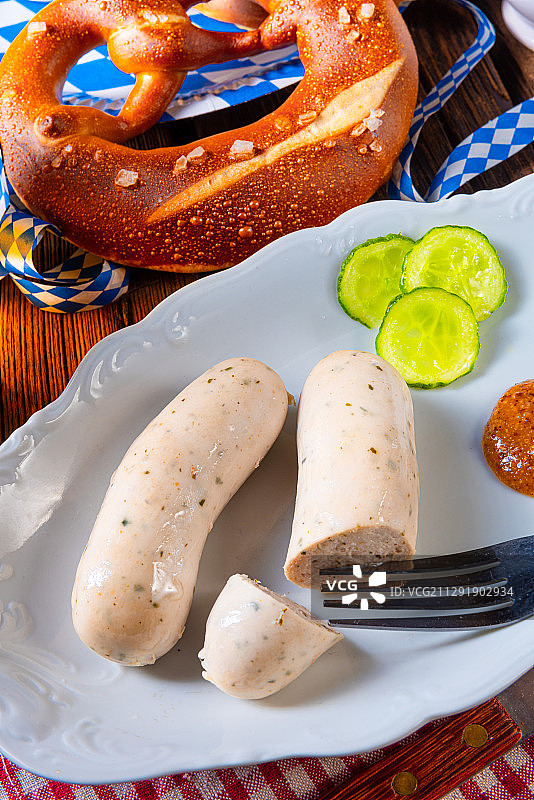 德国埃森：木桌上的巴伐利亚白香肠、椒盐卷饼和啤酒（高角度）图片素材