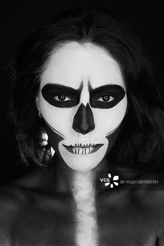 在墨西哥城看着镜头的化着仪式妆容的年轻女人图片素材