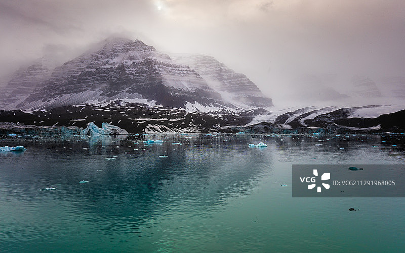 格陵兰的雾中雪山海岸和海中冰山图片素材