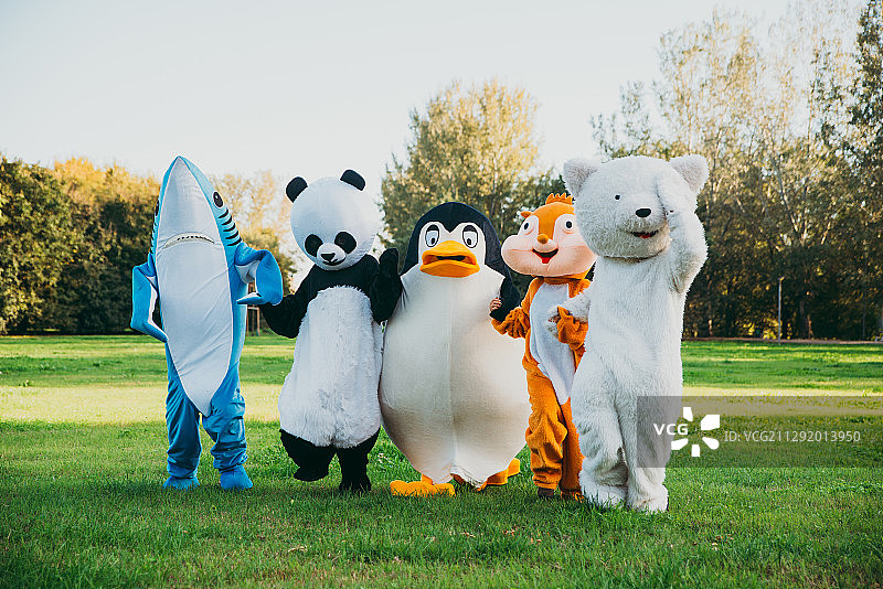 一群穿着野生动物服装的人在公园里手牵着手摆姿势图片素材