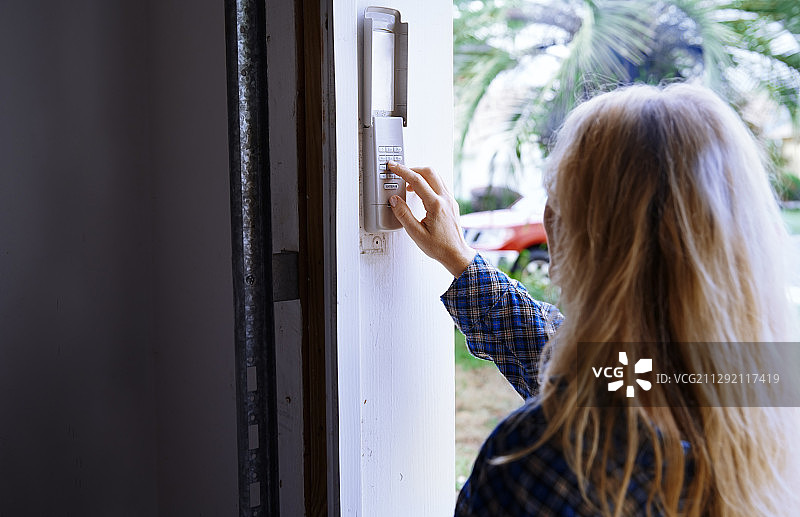 女人在门上解锁密码锁图片素材