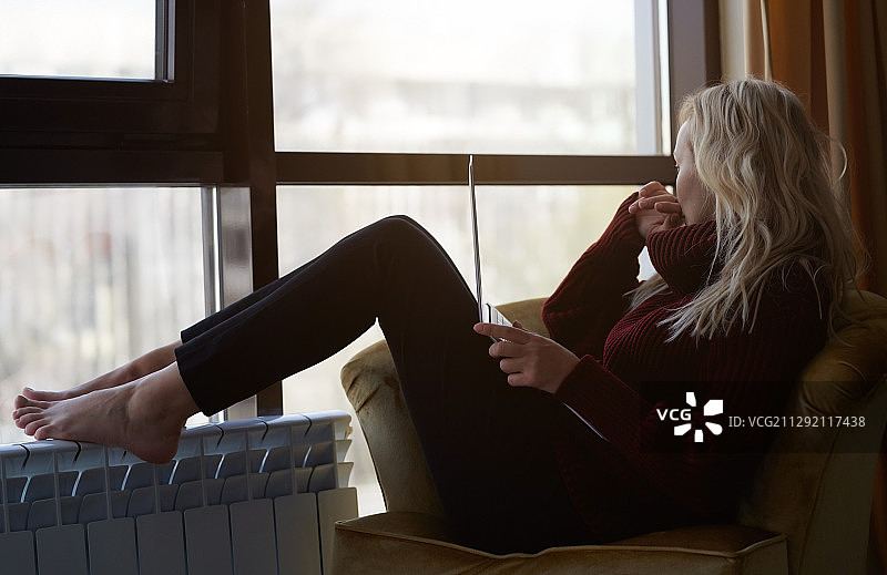 在家用笔记本电脑工作的金发女人图片素材