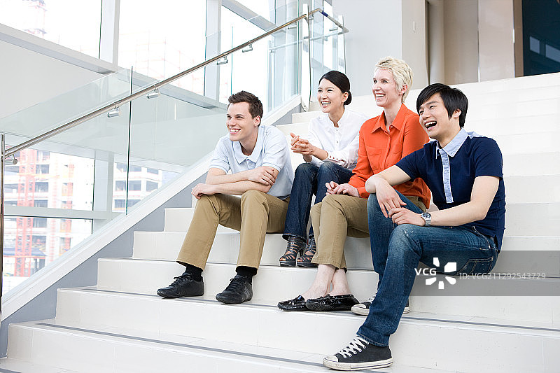 坐在楼梯上的全球商务人士图片素材