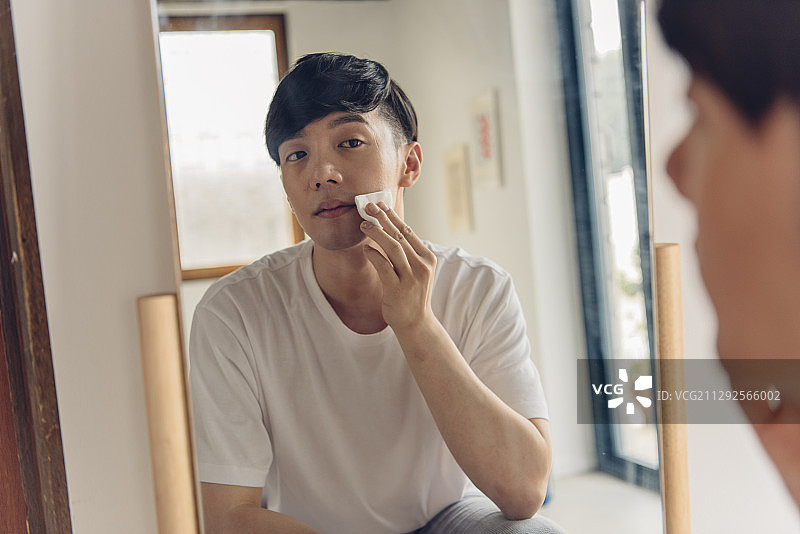 男子用棉球清洁面部图片素材