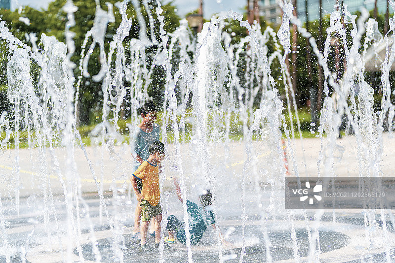 夏季公园里男孩们在喷泉里玩耍图片素材