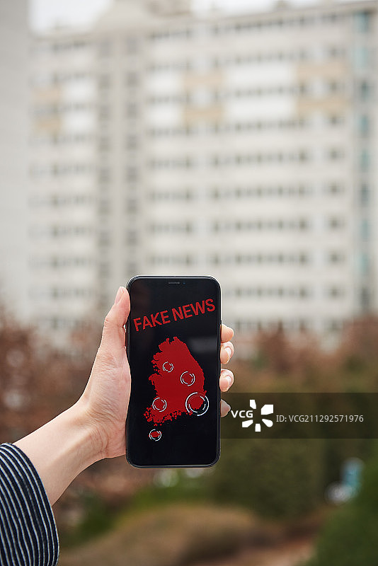 户外手持带假新闻信息的智能手机摄影照片图片素材