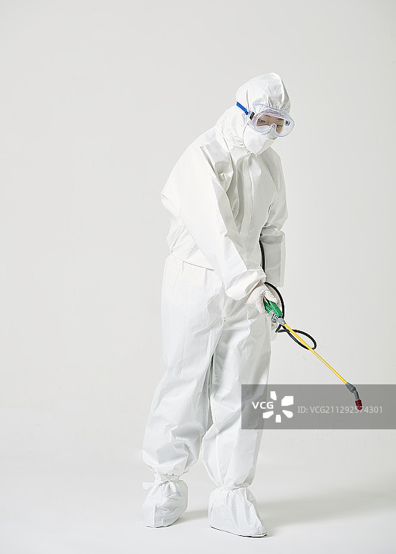身穿防护服的女子用喷雾器消毒图片素材