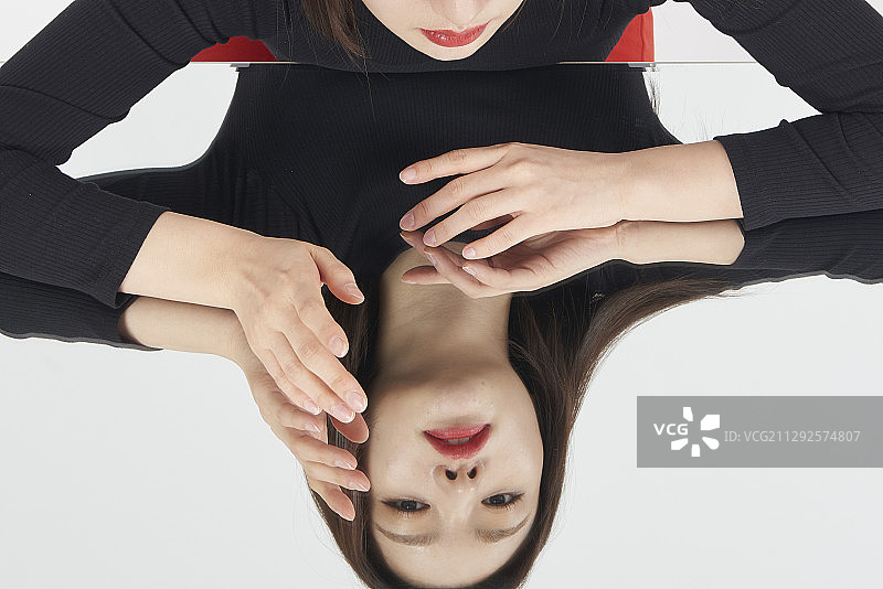 影棚里坐在镜子旁看着镜子的女人图片素材