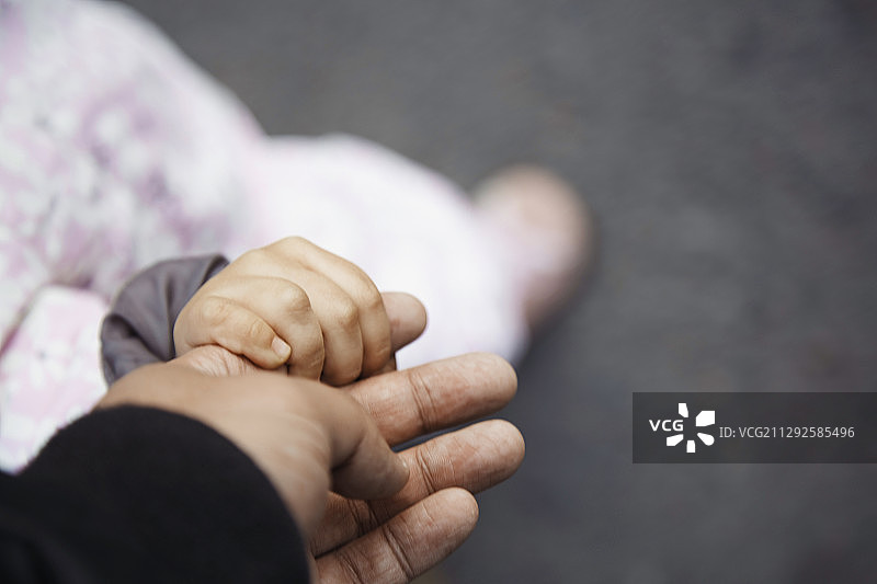 父亲牵着女儿的手在户外行走图片素材