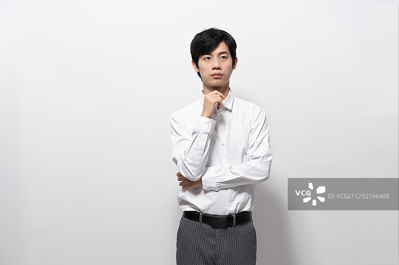 在白色背景前，穿白色衬衫的年轻男人图片素材