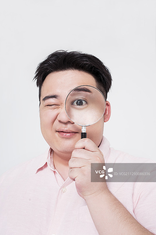 年轻男子使用放大镜图片素材