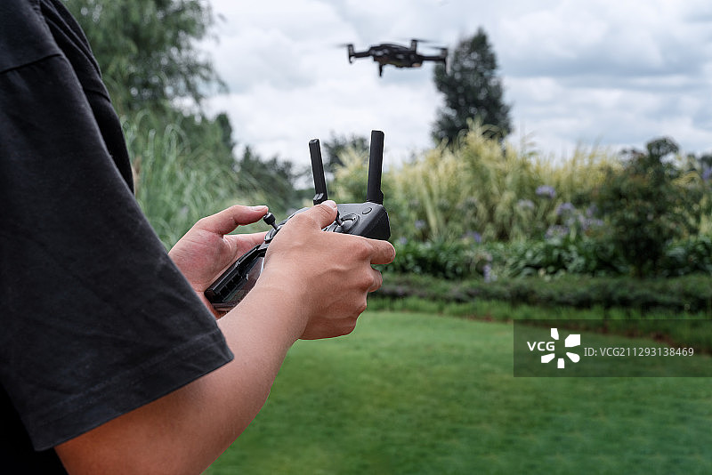 一个中国人在路边操控无人机图片素材