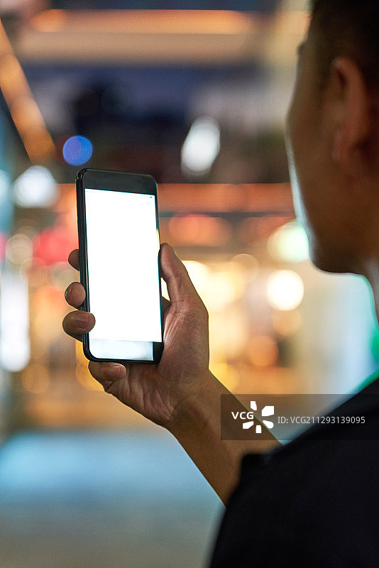 青年男子在商务区拿着手机图片素材