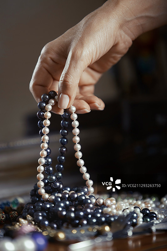 女人手拿珍珠。竖版照片图片素材