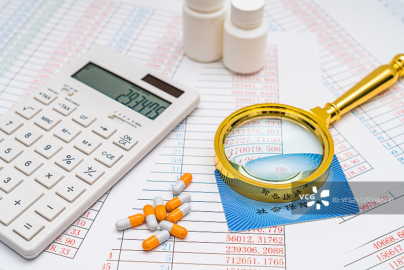 计算器、放大镜社保卡和药品——医疗保险概念图片素材