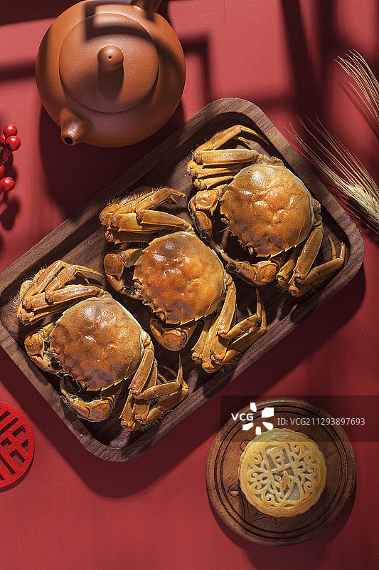 盛放在木盘里的三只美味的大闸蟹图片素材