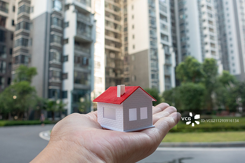 在小区手捧小房子模型图片素材
