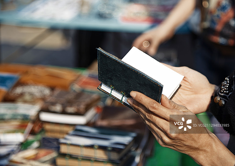 女人在跳蚤市场选择笔记本图片素材
