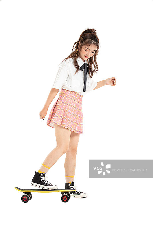 玩耍小滑板的年轻女学生图片素材