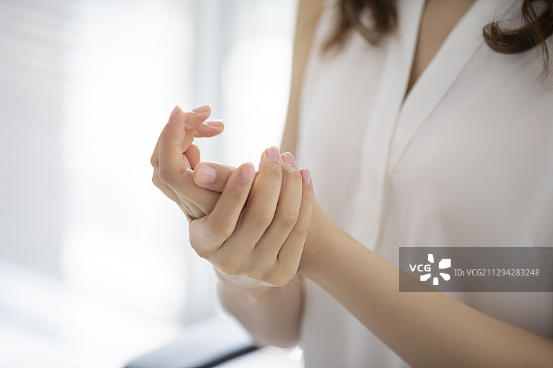 年轻的商务女士在办公室使用免洗洗手液图片素材