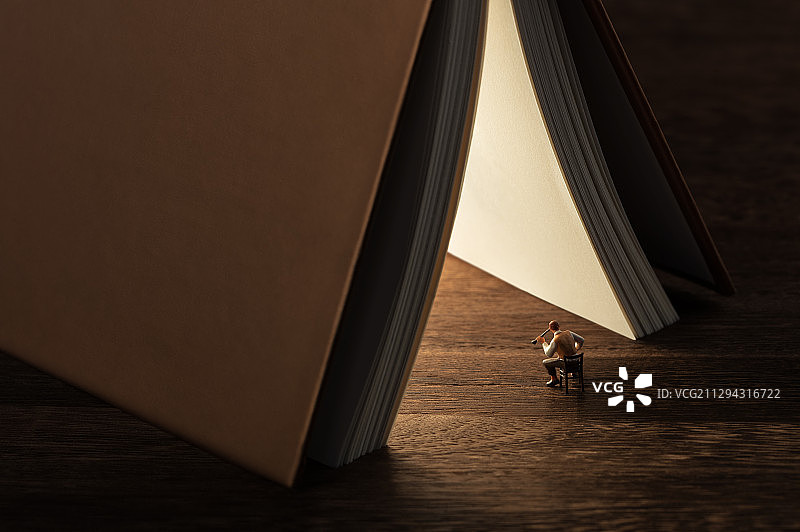 书本里的光照亮听有声小说的人图片素材