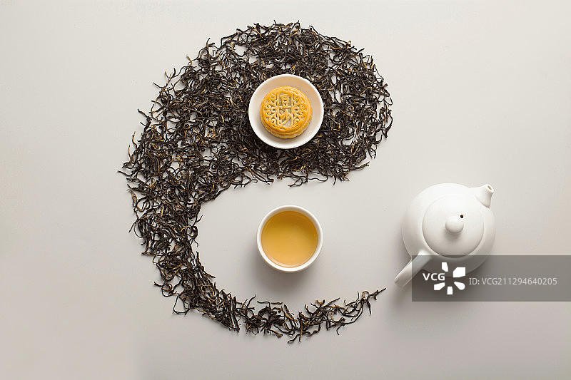 用茶叶铺设的太极图上摆放的月饼和茶杯图片素材