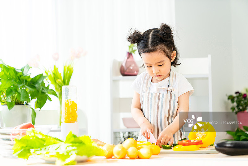 快乐的小女孩在家做饭图片素材
