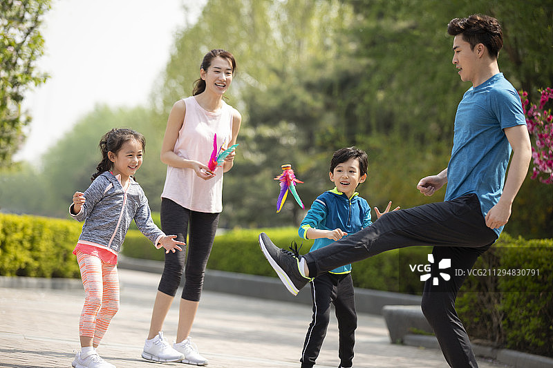 快乐的年轻家庭在公园踢毽子图片素材