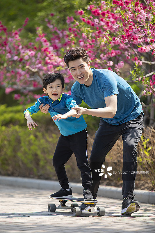 快乐的父子俩玩滑板图片素材