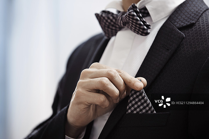 身穿黑色夹克，戴格子领结和手帕的男人特写图片素材