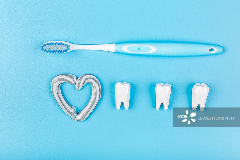 蓝背景上的牙刷和牙齿，爱牙护齿创意图片。图片素材