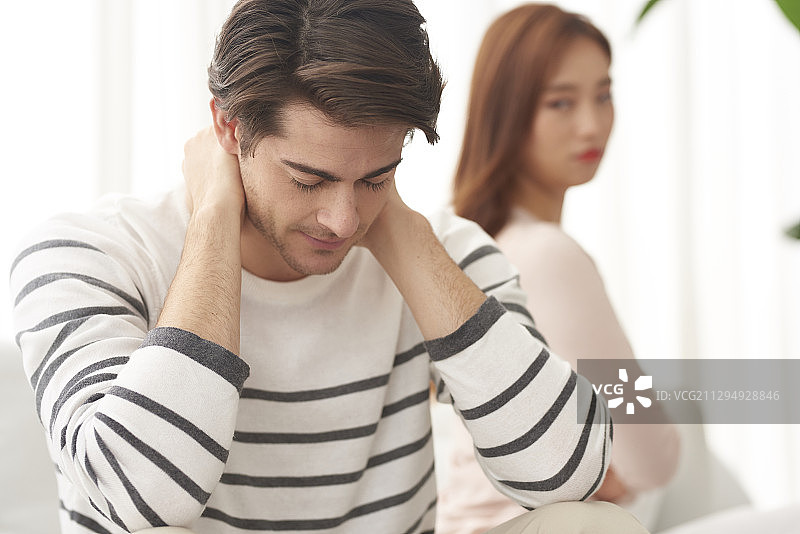 多元文化情侣背靠背坐在沙发上发生冲突图片素材