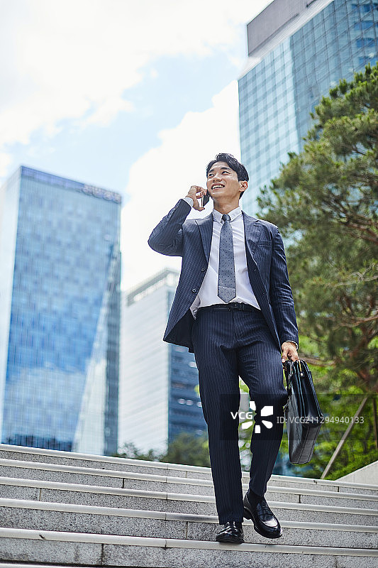 商务沟通：商人用智能手机进行非面对面合同交流图片素材