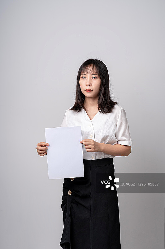 展示A4纸内容的女性职员图片素材