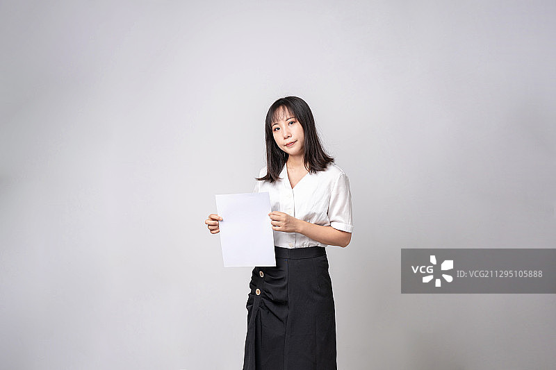 展示A4纸内容的女性职员图片素材