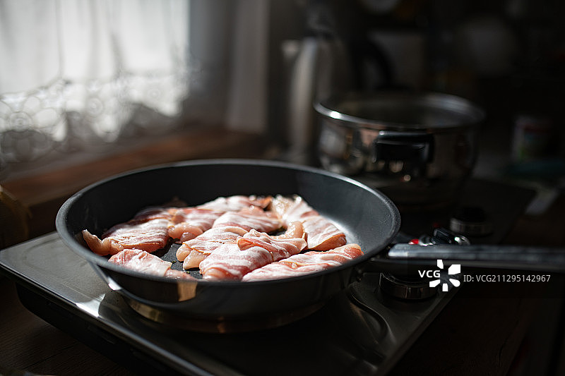在炉子上煎锅中培根的特写，波兰扎科帕内图片素材