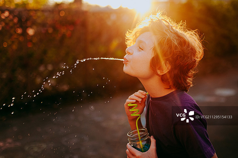在加拿大维多利亚户外，男孩吐出饮料图片素材