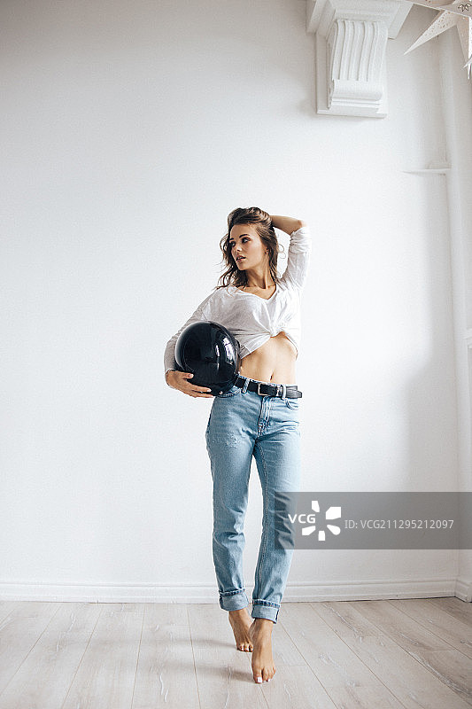 戴着头盔在工作室摆姿势的年轻女子，俄罗斯特维尔图片素材