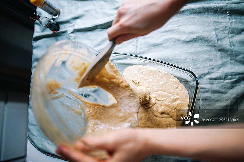 西班牙莱里达，女人将香蕉面包面糊倒入烤盘图片素材