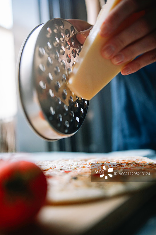 在西班牙列伊达，在家预备披萨的女子（腰部视角）图片素材