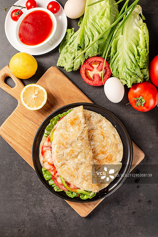 黑色背景上盘子里装着美味小吃手抓饼图片素材