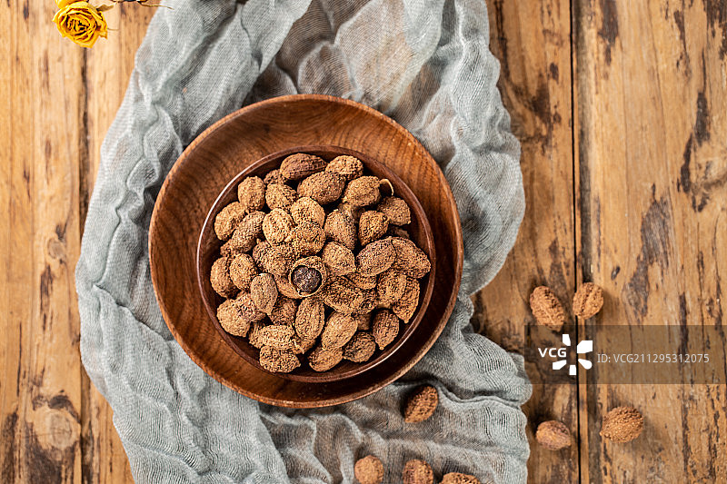 木板背景上满满一碗调味料砂仁图片素材