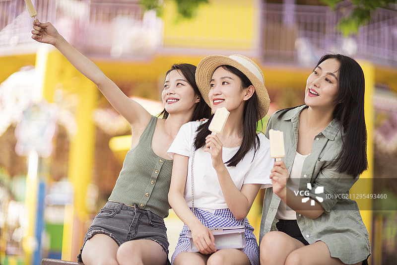 闺蜜在游乐场游玩吃冰棍图片素材