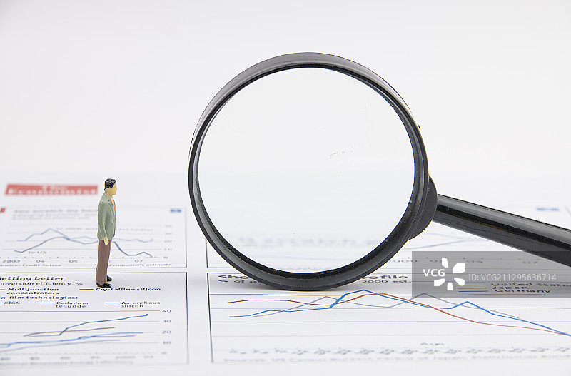 商业图表上站着一位商务 人士和一个放大镜图片素材