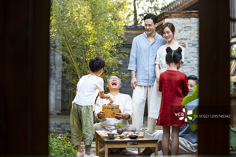 中秋节一家六口聚会孙女、孙子给爷爷、奶奶送礼物图片素材