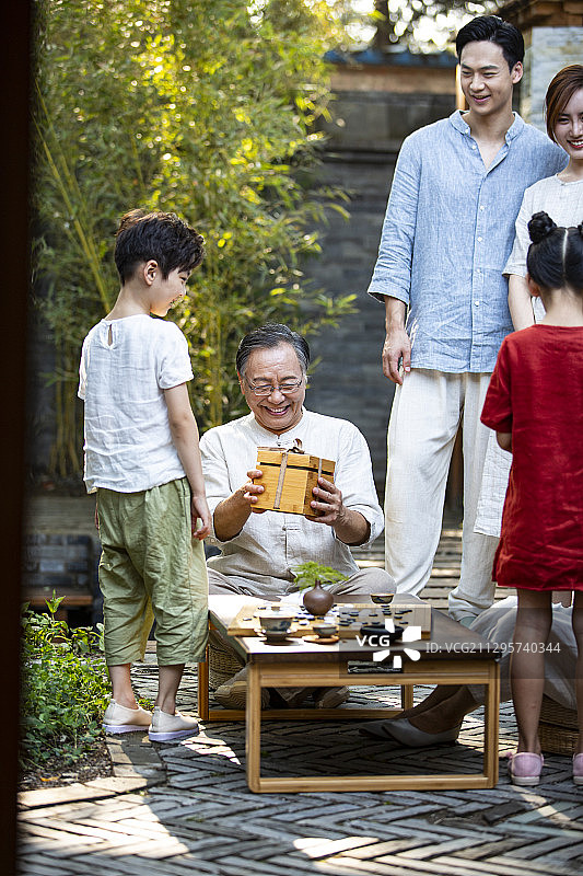 中秋节一家六口聚会孙女、孙子给爷爷、奶奶送礼物图片素材